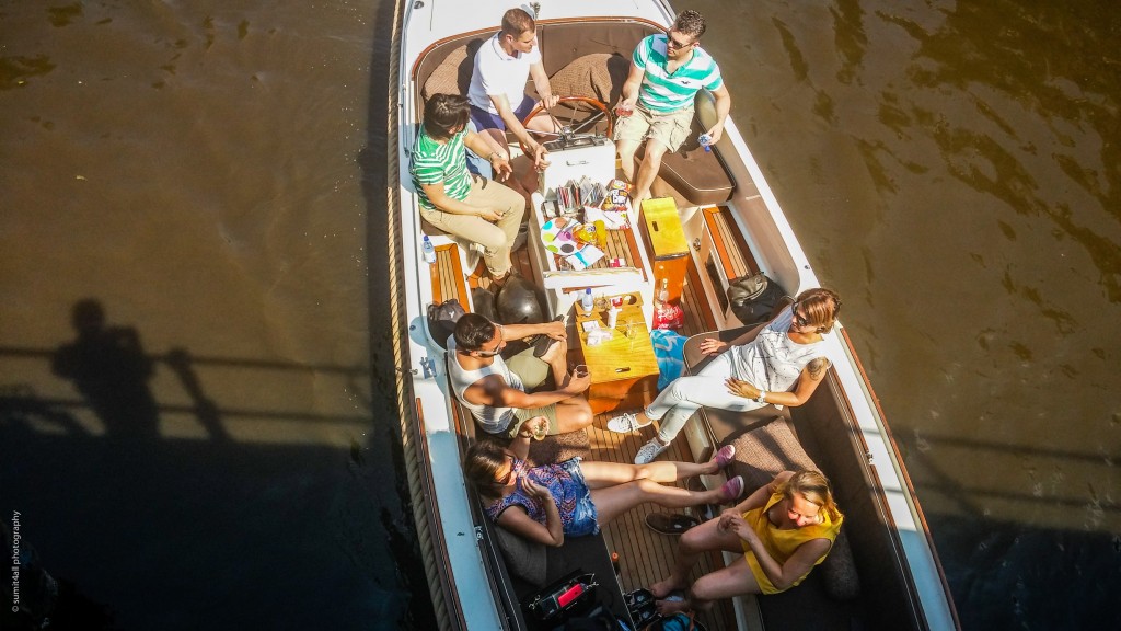 A boat party overlooked from a bridge