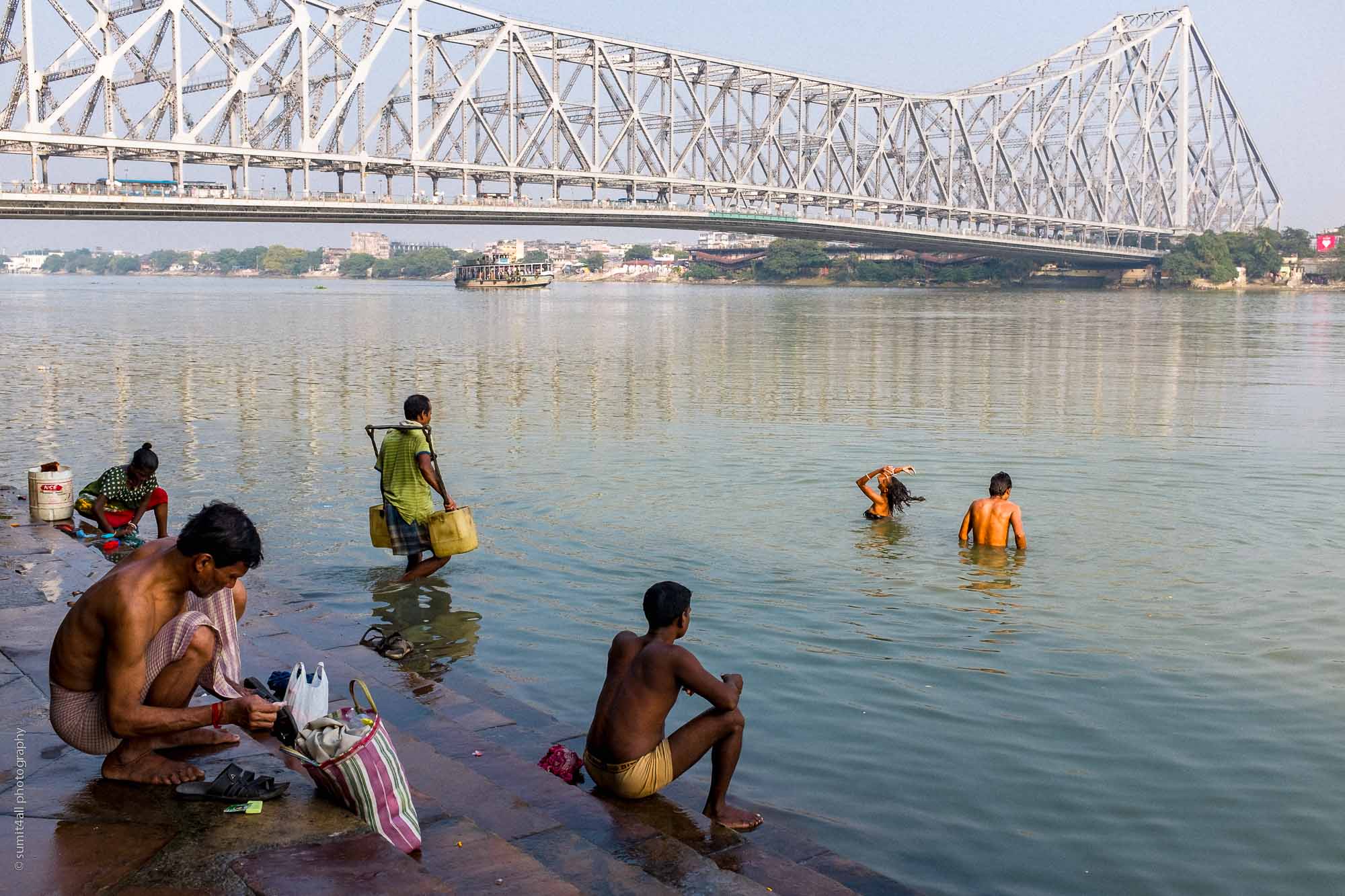 People bathing near the Howrah Bridge in Kolkata