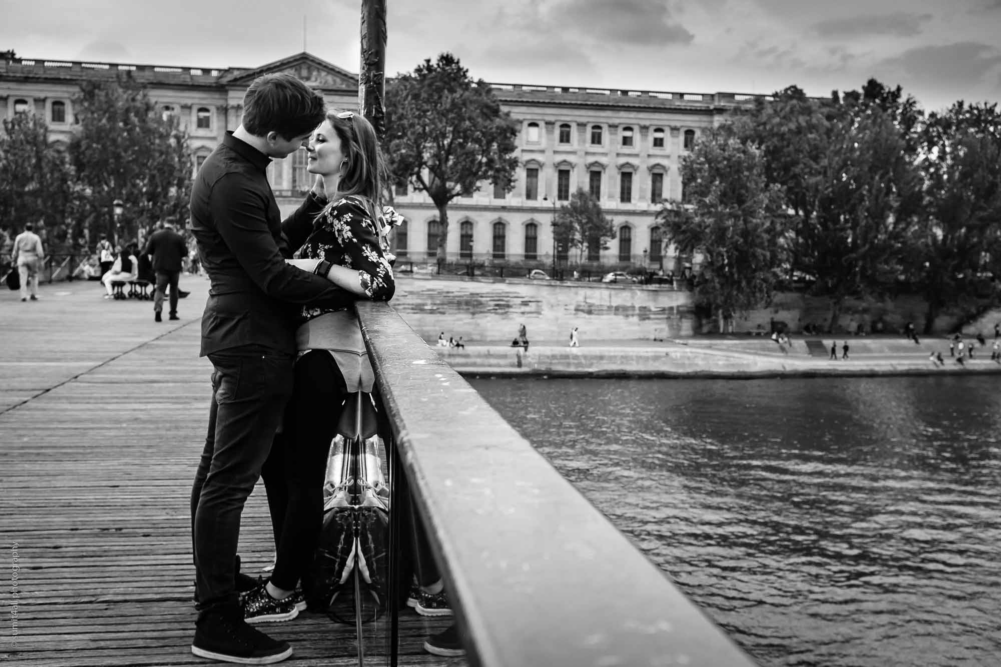 A couple kiss over a bridge on the Seine River in Paris