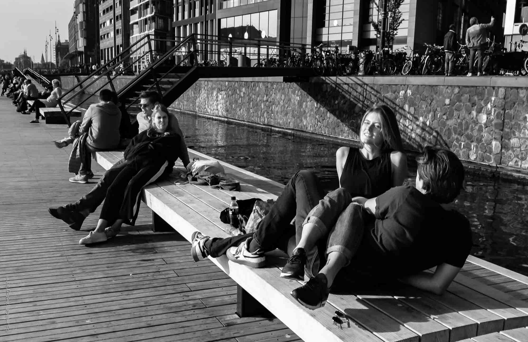 People Enjoying Sunshine In The Oosterdok Island in Amsterdam